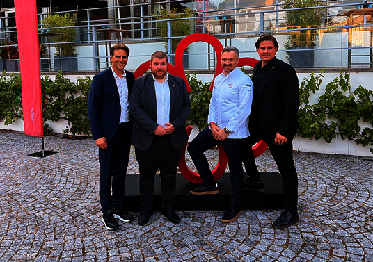 Thomas Mack, Loic Schwebel, Peter Hagen-Wiest and Felix Heuberger in front of a statue of the MICHELIN star