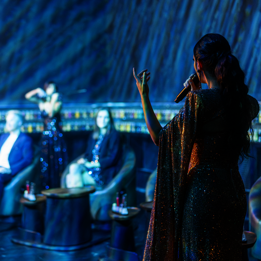 Taste - Eatrenalin Late Night A saxophonist playing at Eatrenalin Late Night. A woman can be seen in the background.